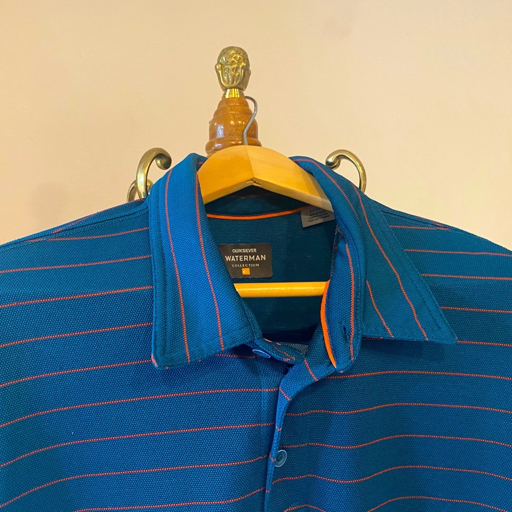 MEN’s LARGE QUIKSILVER WATERMAN COLLECTION POLO SHIRT. DARK BLUE, ORANGE STRIPES